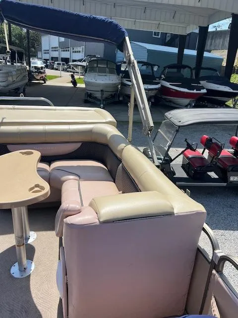 Slide: The Image of 2008 Godfrey SANPAN 2500 DC pontoon boat with seating and table, docked in a marina. - 9