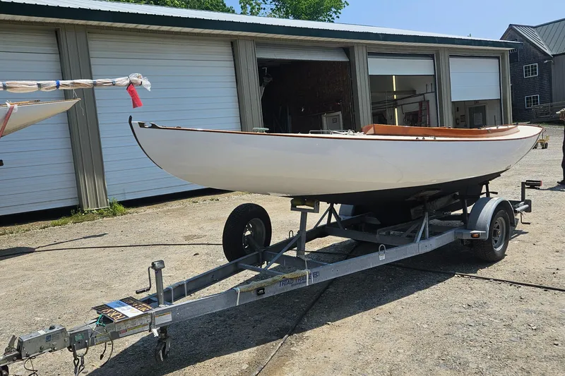 Slide: The Image of 1995 Herreshoff Watch Hill 15 sailboat on a trailer outside a garage. - 10