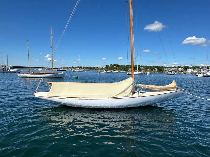 Slide: The Image of Herreshoff Watch Hill 15 sailboat from 1995 moored on calm water under blue sky. - 4