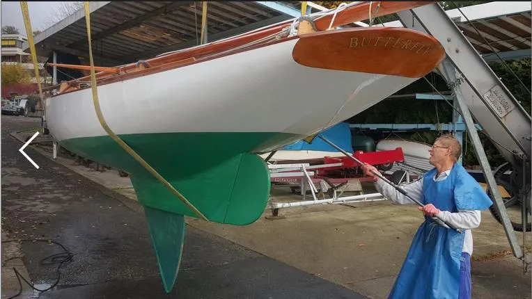 Slide: The Image of Person painting a 1995 Herreshoff Watch Hill 15 sailboat hull in a boatyard. - 7