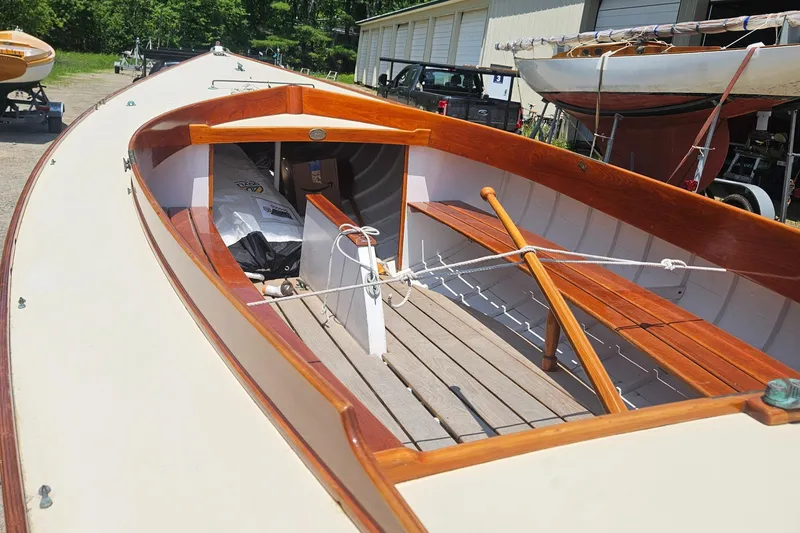 Slide: The Image of 1995 Herreshoff Watch Hill 15 sailboat with wooden interior and deck, docked outdoors. - 9