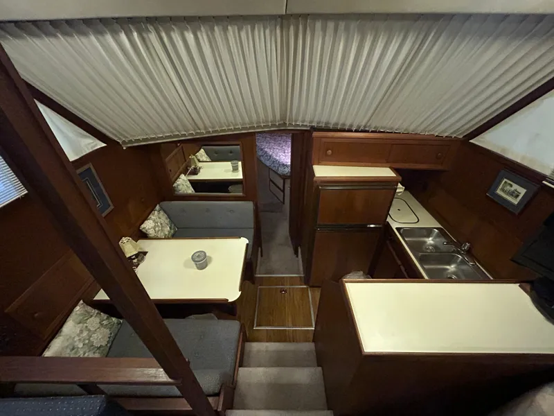 Slide: The Image of Interior of 1987 Chris-Craft 362 Catalina yacht, featuring dining area and compact kitchen. - 20