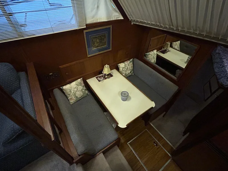 Slide: The Image of 1987 Chris-Craft 362 Catalina interior with cozy dining area and wooden accents. - 22