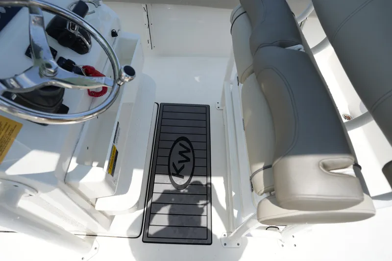Slide: The Image of 2023 Key West 219 FS boat interior with steering wheel and cushioned seating. - 22