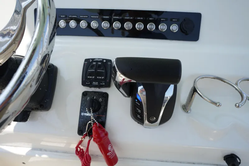 Slide: The Image of 2023 Key West 219 FS boat dashboard with controls and steering wheel. - 25