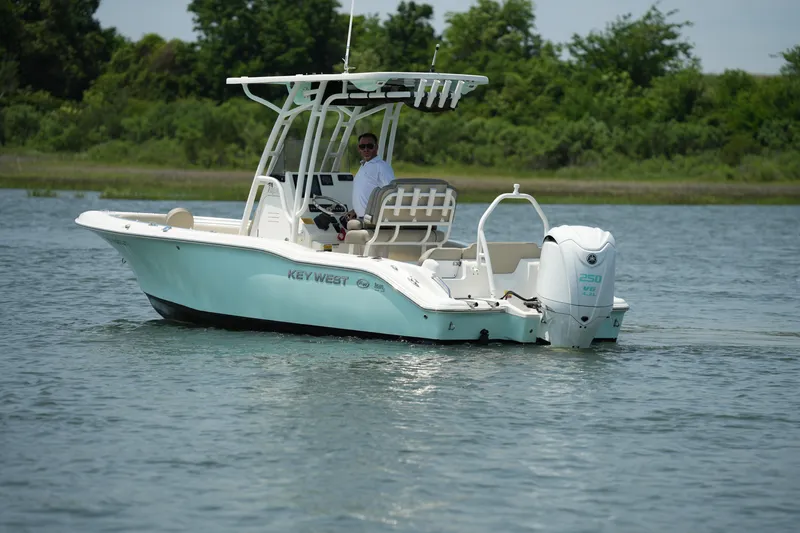 Slide: The Image of 2023 Key West 219 FS boat on water, with lush greenery in the background. - 3