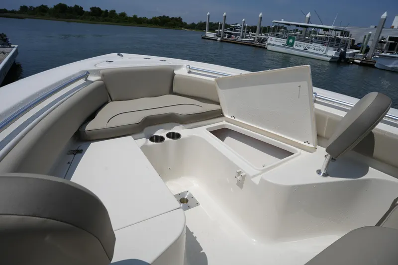 Slide: The Image of 2023 Key West 219 FS boat interior with seating and storage, docked by the water. - 35