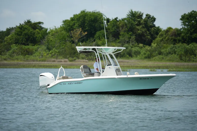 Slide: The Image of 2023 Key West 219 FS boat on calm water with lush green background. - 7