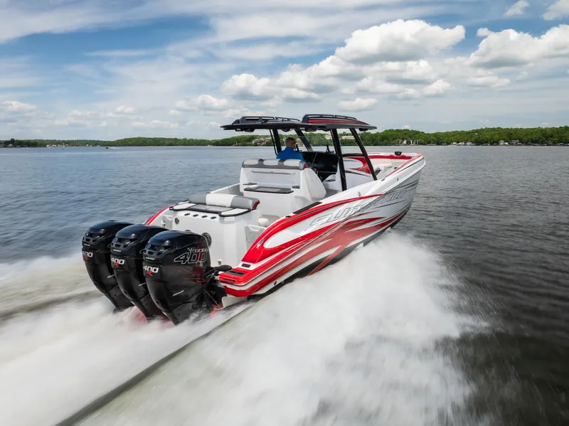 Slide: The Image of 2017 Sunsation 34 CCX speedboat with triple engines cruising on a lake under a blue sky. - 11