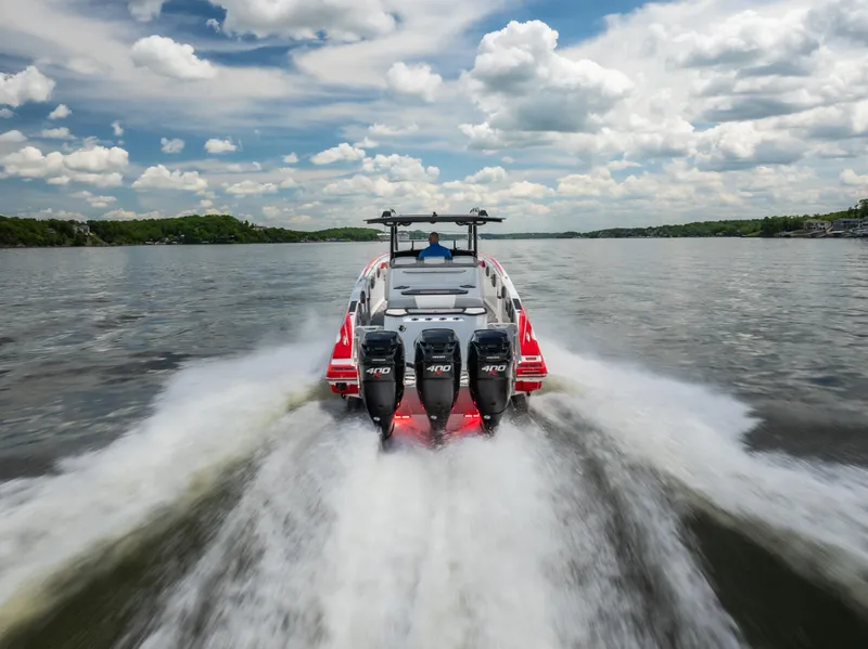 Slide: The Image of 2017 Sunsation 34 CCX speedboat with four engines cruising on a lake under a cloudy sky. - 13