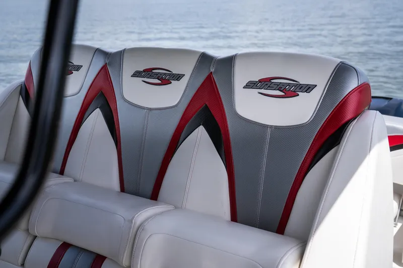 Slide: The Image of 2017 Sunsation 34 CCX boat seats with red and gray accents on the water. - 17