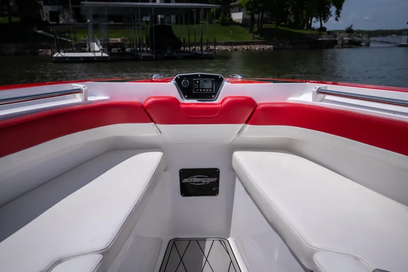 Slide: The Image of 2017 Sunsation 34 CCX boat interior with red and white seating, docked by a lake. - 24