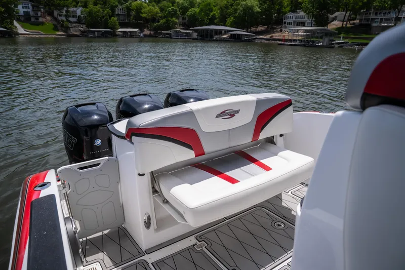 Slide: The Image of 2017 Sunsation 34 CCX boat with triple engines, featuring a sleek rear seating area on a lake. - 32