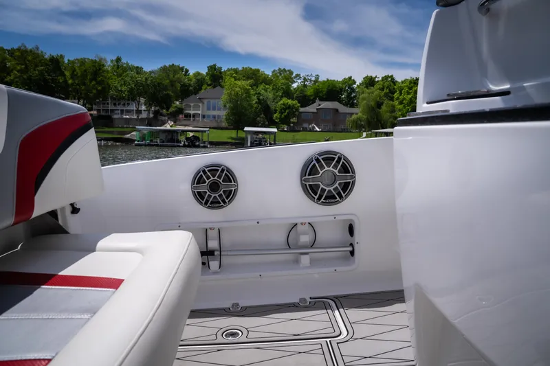 Slide: The Image of 2017 Sunsation 34 CCX boat interior with speakers, white and red seating, and scenic lake view. - 33