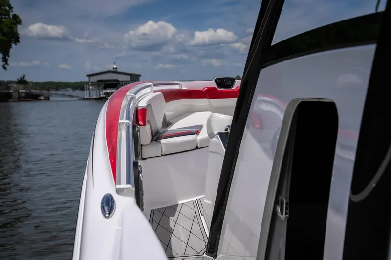 Slide: The Image of 2017 Sunsation 34 CCX boat with red and white interior on a calm lake. - 36