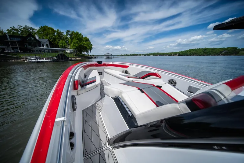 Slide: The Image of 2017 Sunsation 34 CCX boat with sleek red and white interior on a scenic lake. - 41