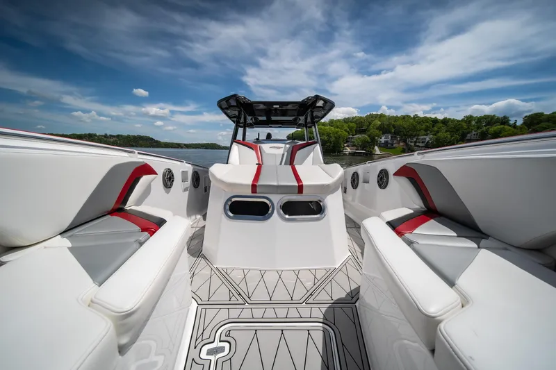 Slide: The Image of 2017 Sunsation 34 CCX boat interior with sleek white and red seating, under a clear blue sky. - 42