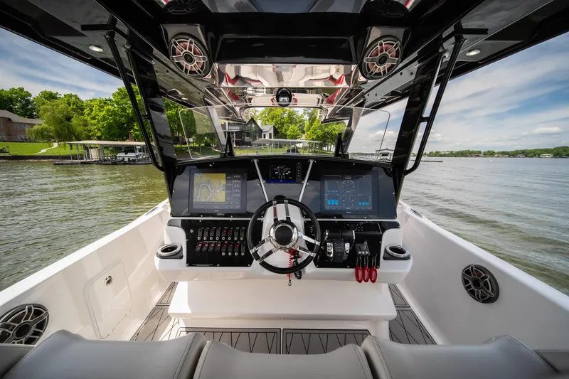 Slide: The Image of 2017 Sunsation 34 CCX boat cockpit with advanced navigation system on a serene lake. - 44