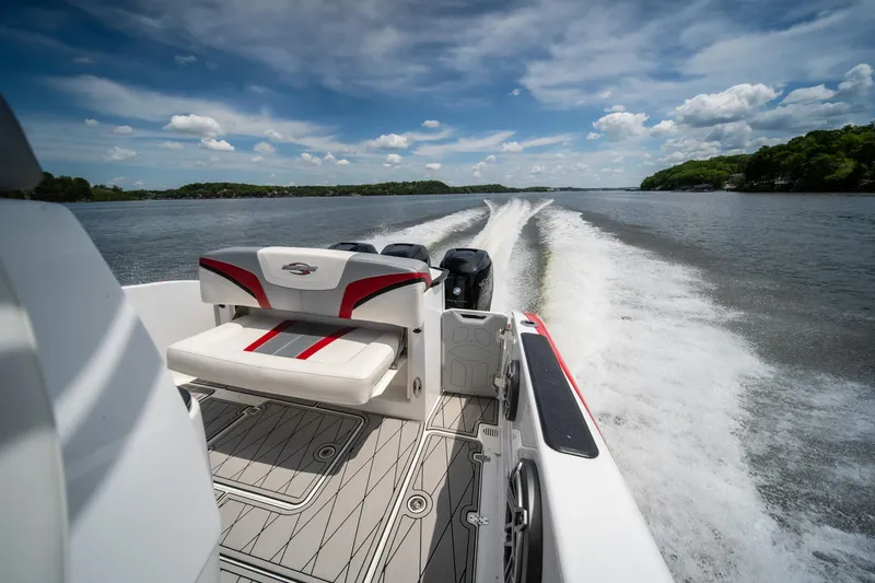 Slide: The Image of 2017 Sunsation 34 CCX boat cruising on a lake under a partly cloudy sky. - 47