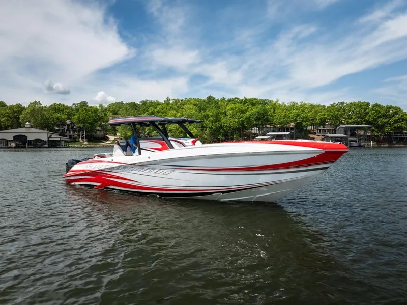 Slide: The Image of 2017 Sunsation 34 CCX boat on a lake with vibrant red and white design. - 6