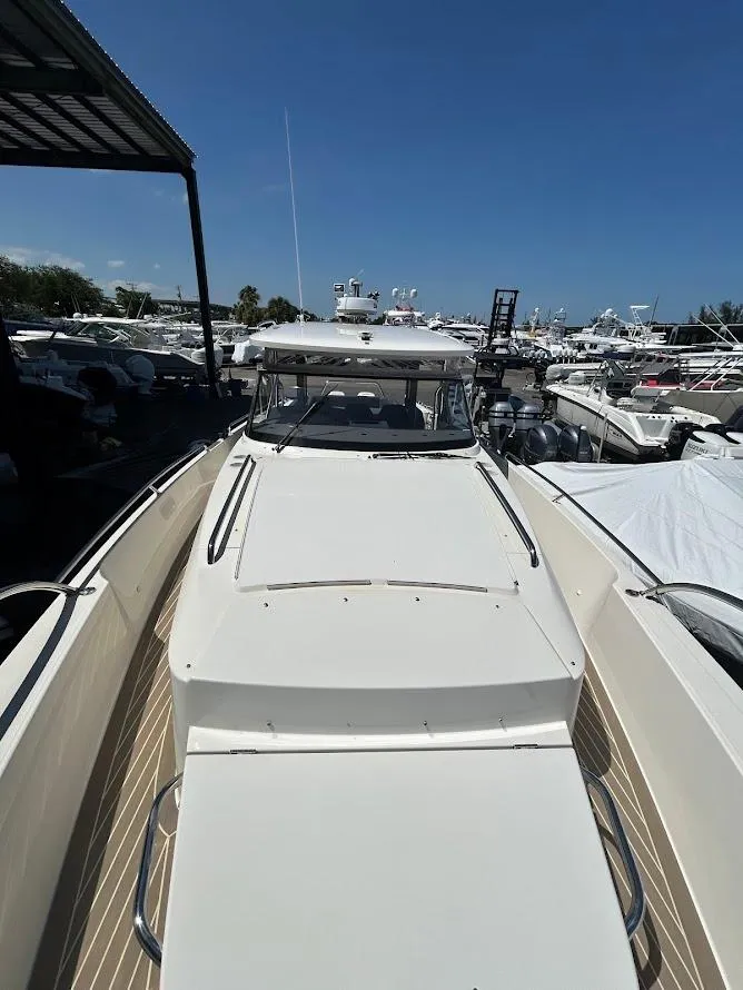 Slide: The Image of Luxurious seating area on 2022 Nimbus T11 boat with wooden table, overlooking serene waters. - 7