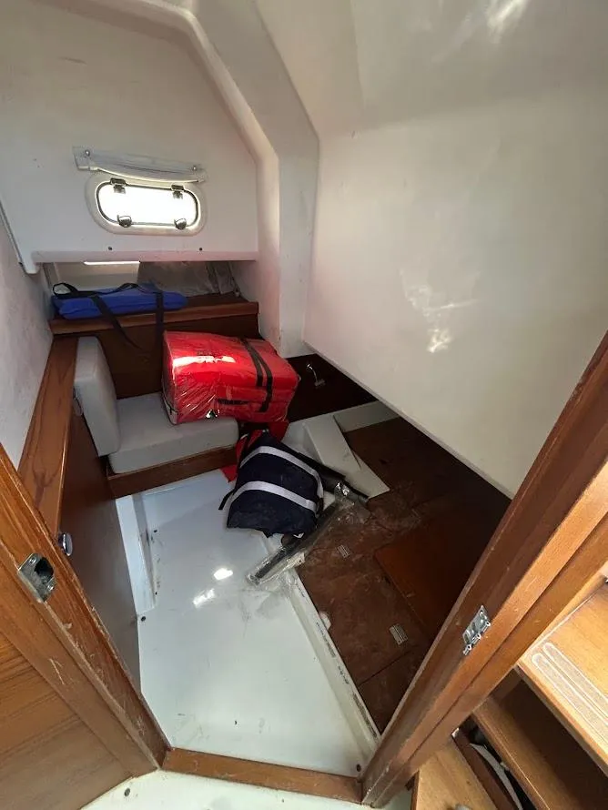 Slide: The Image of 2022 Nimbus T11 boat interior with kitchenette, featuring sink and storage, overlooking water. - 11