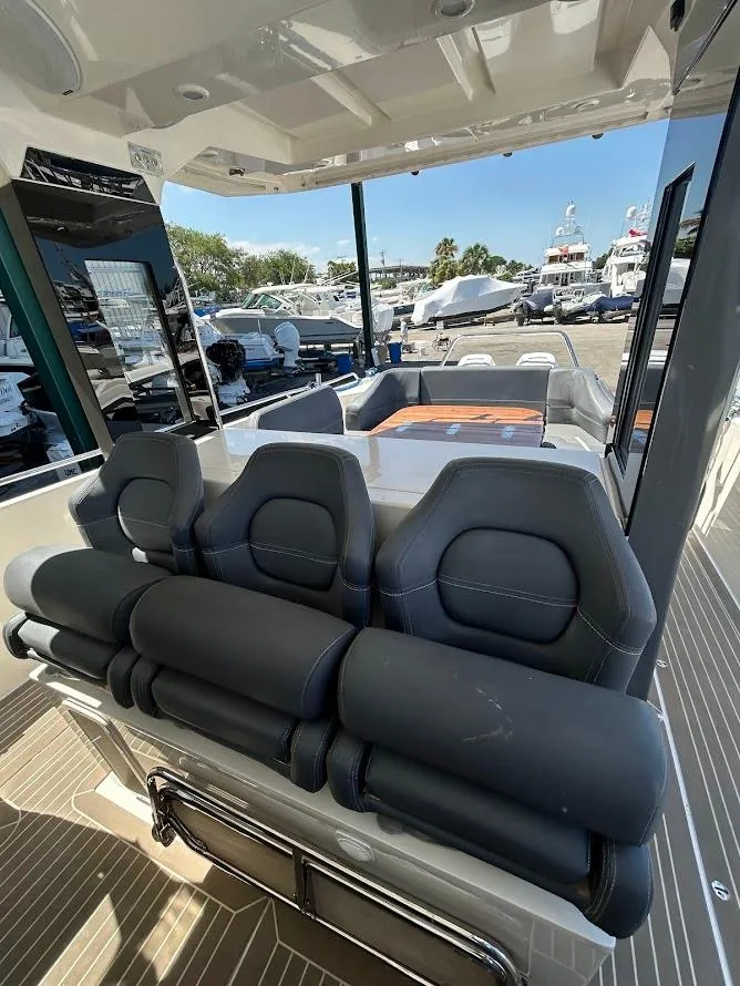 Slide: The Image of Luxury Nimbus T11 yacht deck with seating, table, and canopy, overlooking serene blue waters. - 9