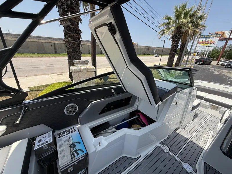 Slide: The Image of 2019 Monterey MX6 SURF boat interior with open storage compartment and accessories. - 46