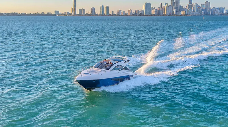 Slide: The Image of Schaefer 375 yacht cruising on blue ocean with city skyline in background, 2023 model. - 3