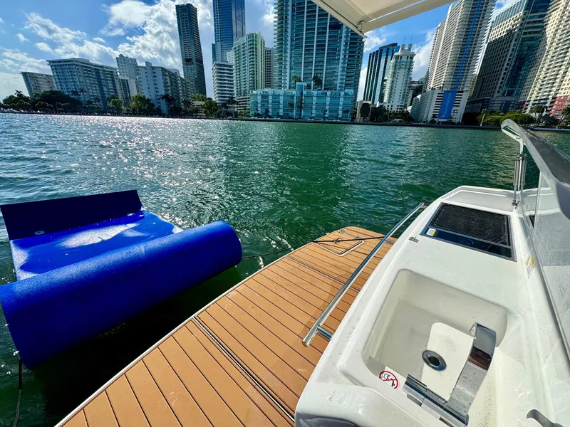 Slide: The Image of 2023 Schaefer 375 yacht docked with city skyline and floating mat on water. - 31