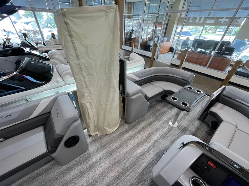 Slide: The Image of Interior of 2025 Bennington 22SXSRC pontoon boat with gray seating and table in showroom. - 11