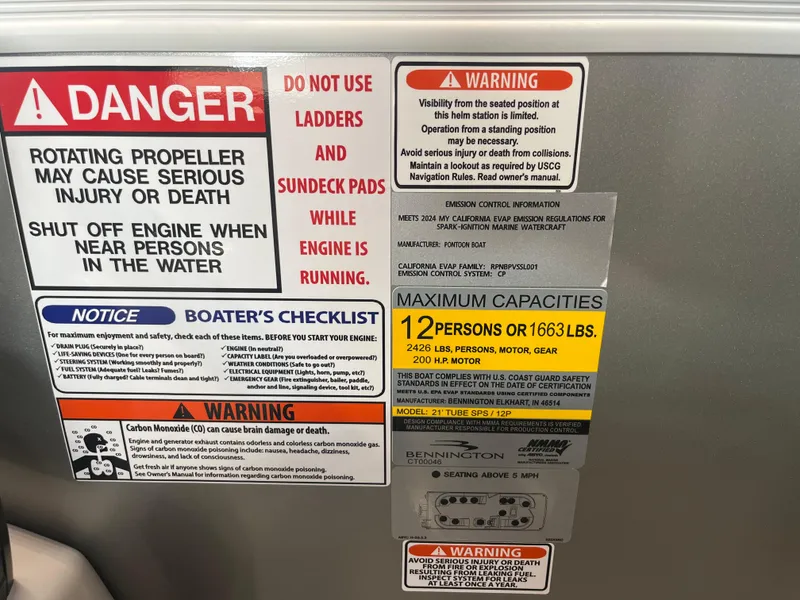 Slide: The Image of Warning labels and capacity information on a 2025 Bennington 22SXSRC boat. - 12