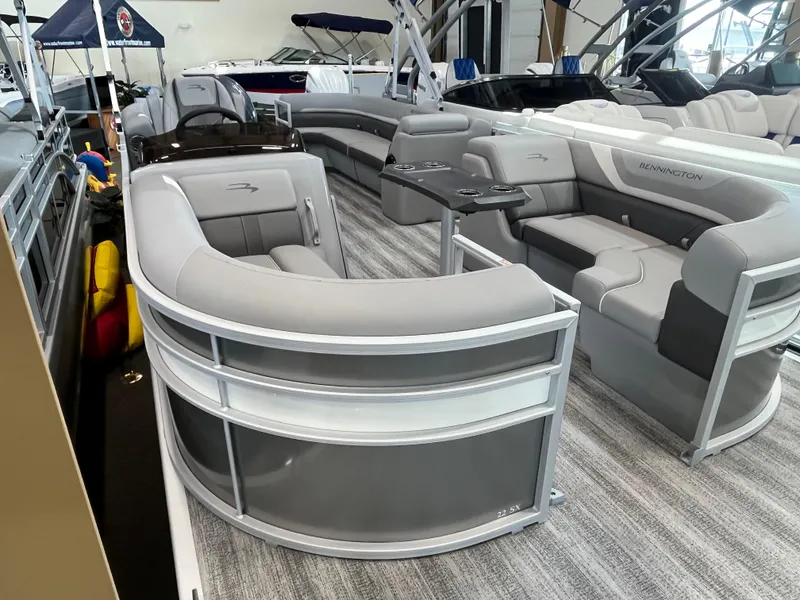 Slide: The Image of 2025 Bennington 22SXSRC pontoon boat with luxurious seating and modern design in a showroom. - 16