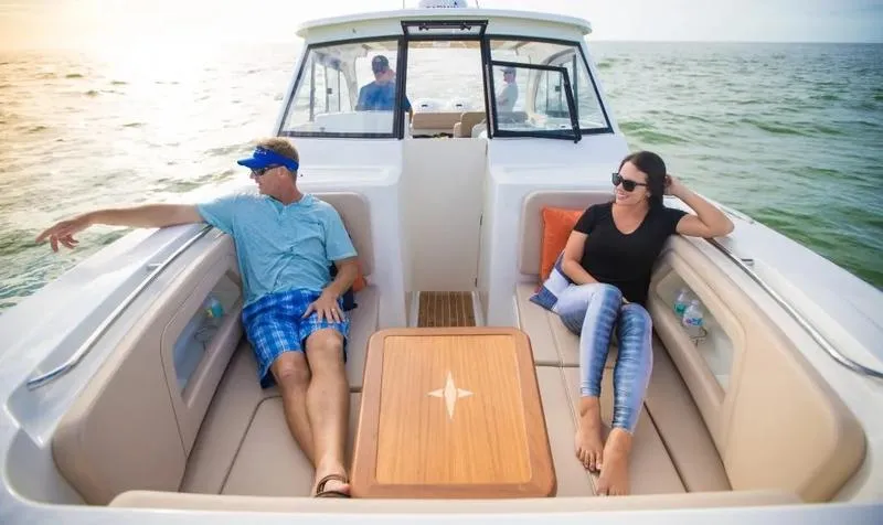 Slide: The Image of 2025 Southport 33 DC boat with passengers relaxing on deck at sea. - 2