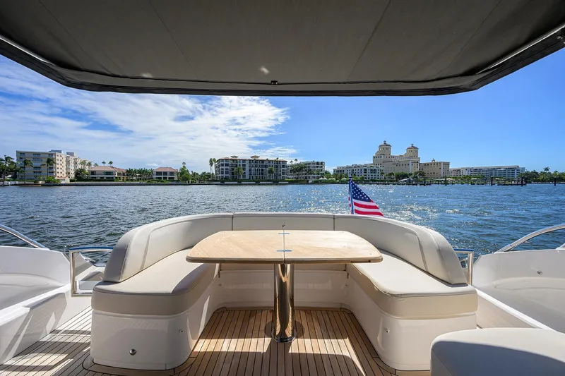 Slide: The Image of Luxurious 2026 Princess V50 Deck Salon yacht with waterfront view and American flag. - 5