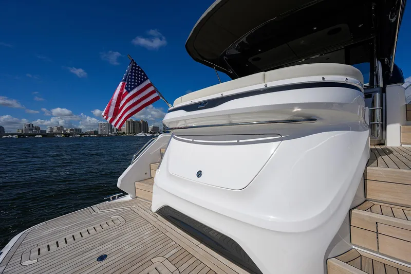 Slide: The Image of 2026 Princess V50 Deck Salon yacht with American flag, docked on a sunny day. - 52