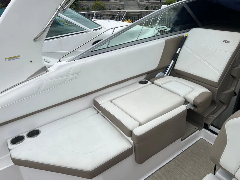 Slide: The Image of 2018 Regal Commodore 258 boat with blue cover, parked near brick building under cloudy sky. - 10