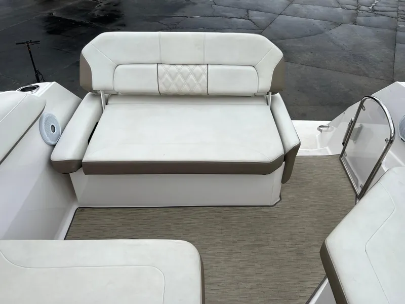 Slide: The Image of 2018 Regal Commodore 258 boat interior with steering wheel and seating, docked near buildings. - 11