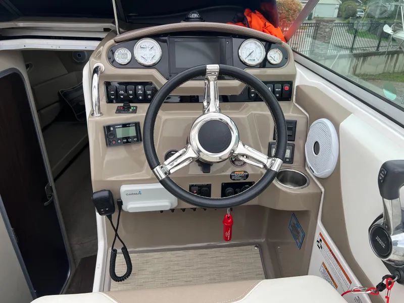 Slide: The Image of 2018 Regal Commodore 258 boat interior with beige and white seating, cup holders, and carpeted flooring. - 12