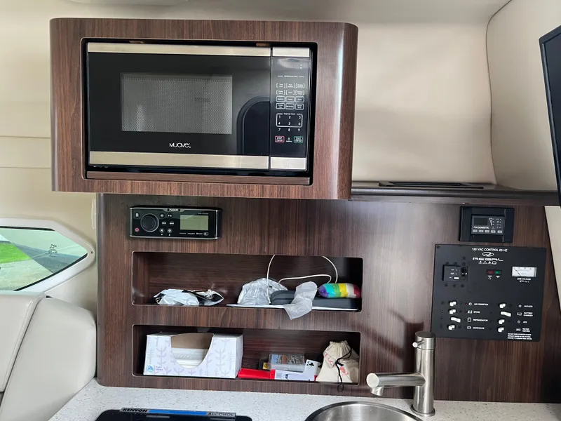 Slide: The Image of 2018 Regal Commodore 258 boat interior with kitchenette, sink, and mini fridge. - 18