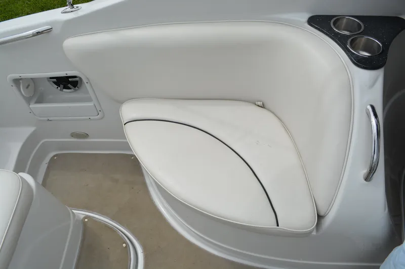 Slide: The Image of 2007 Crownline 275 CCR boat interior with white cushioned seating and cup holders. - 14