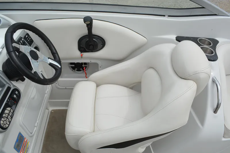 Slide: The Image of 2007 Crownline 275 CCR boat interior with white captain's seat and steering controls. - 16