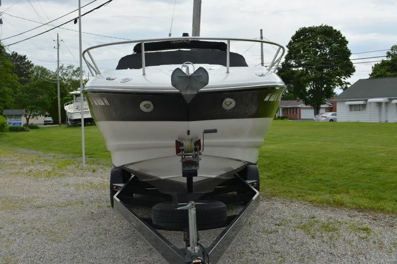Slide: The Image of 2007 Crownline 275 CCR boat on trailer, parked on gravel with grassy background. - 5