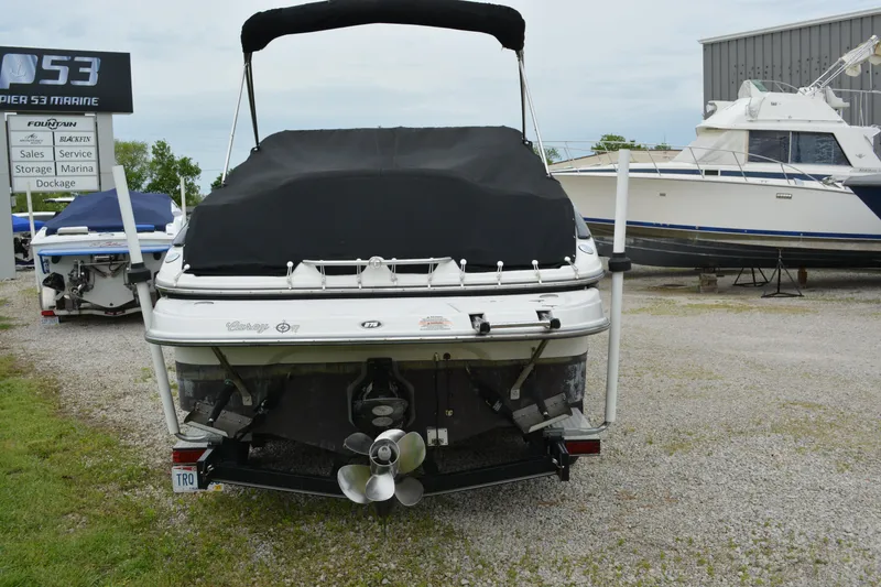 Slide: The Image of 2007 Crownline 275 CCR boat with black cover, parked on gravel near other boats. - 6
