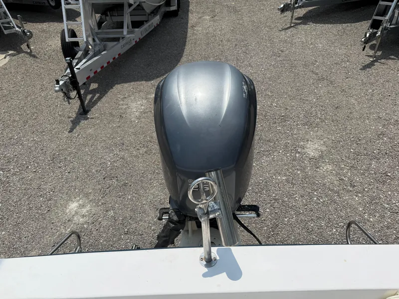 Slide: The Image of 1993 Grady-White Explorer 24 outboard motor on gravel, with trailers in background. - 12