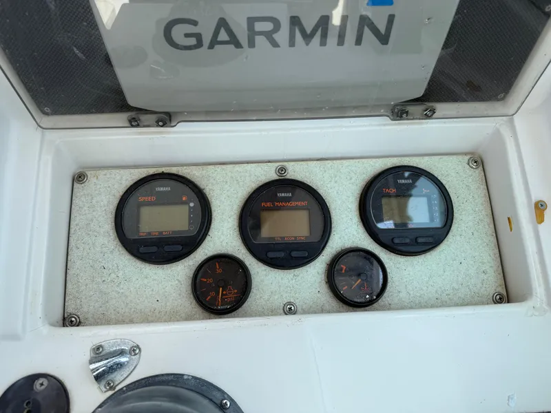 Slide: The Image of 1993 Grady-White Explorer 24 dashboard with Garmin navigation and multiple gauges. - 21