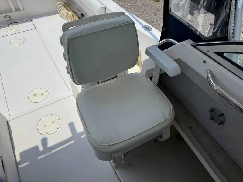 Slide: The Image of 1993 Grady-White Explorer 24 boat interior with white cushioned seat and control panel. - 26