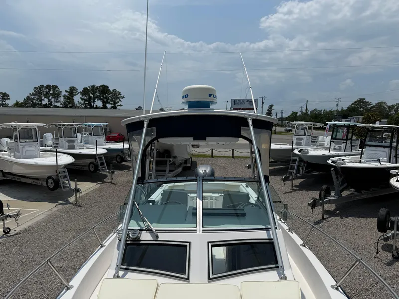 Slide: The Image of 1993 Grady-White Explorer 24 boat displayed in a dealership lot under a cloudy sky. - 28