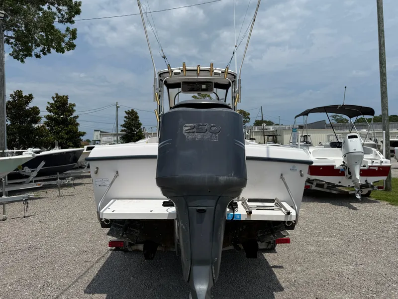 Slide: The Image of 1993 Grady-White Explorer 24 boat with powerful outboard motor, parked on gravel lot. - 5