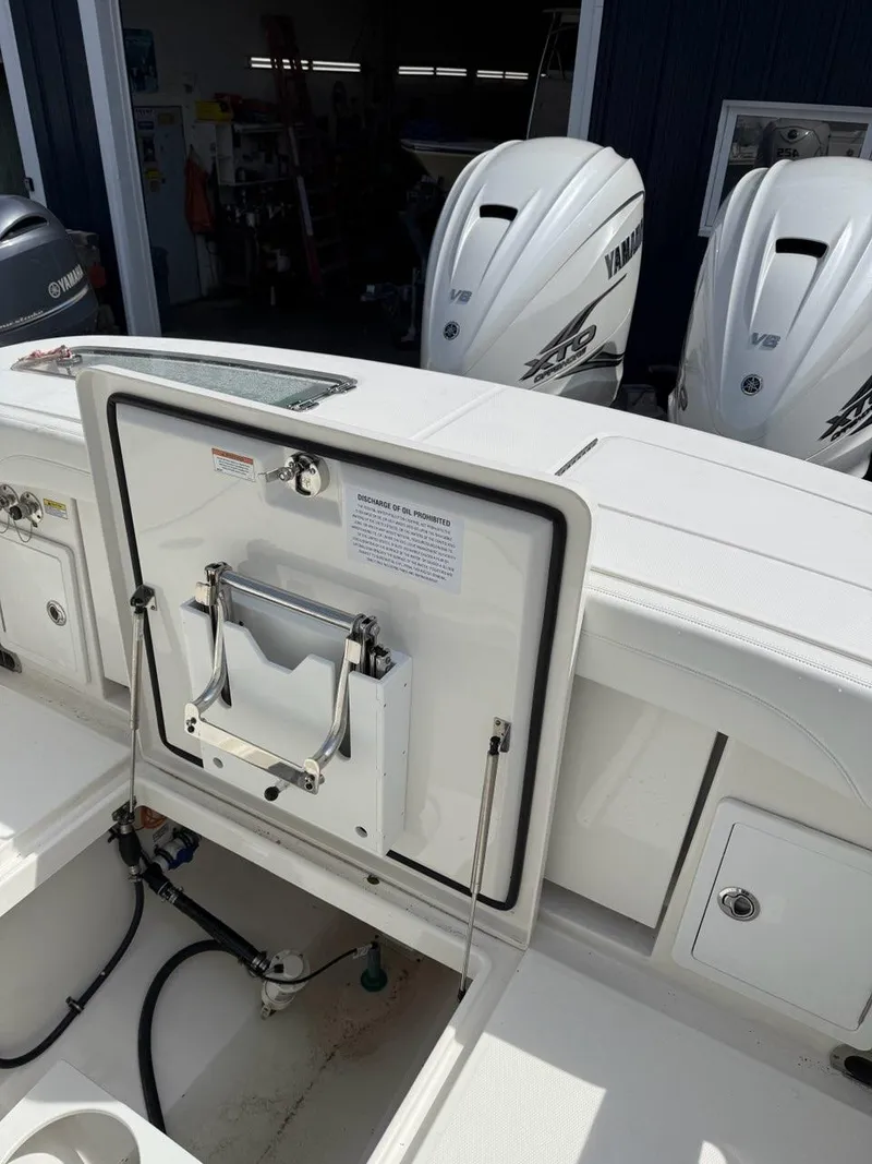 Slide: The Image of 2021 Regulator 31 boat with Yamaha engines, featuring a clean, white deck and storage compartments. - 13